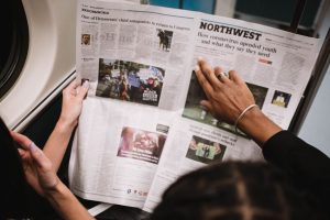 People reading a newspaper on a subway train, highlighting current events and diverse perspectives. — MyStake Casino: Snelle