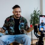 Casual man vlogging in a modern living room using smartphone on tripod, expressing thoughts. — The Founding of YouTube A Shor
