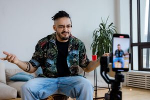 Casual man vlogging in a modern living room using smartphone on tripod, expressing thoughts. — The Founding of YouTube A Shor