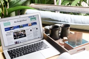 High angle of modern laptop with news on screen placed on table next to tin cups — Wie du die besten Angebote im Candy Casino