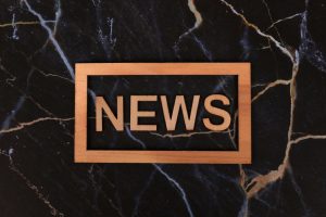 Wooden text of 'news' outlined on a dark, marbled surface, creating a striking contrast. — Winrolla Casino: Besondere Feature